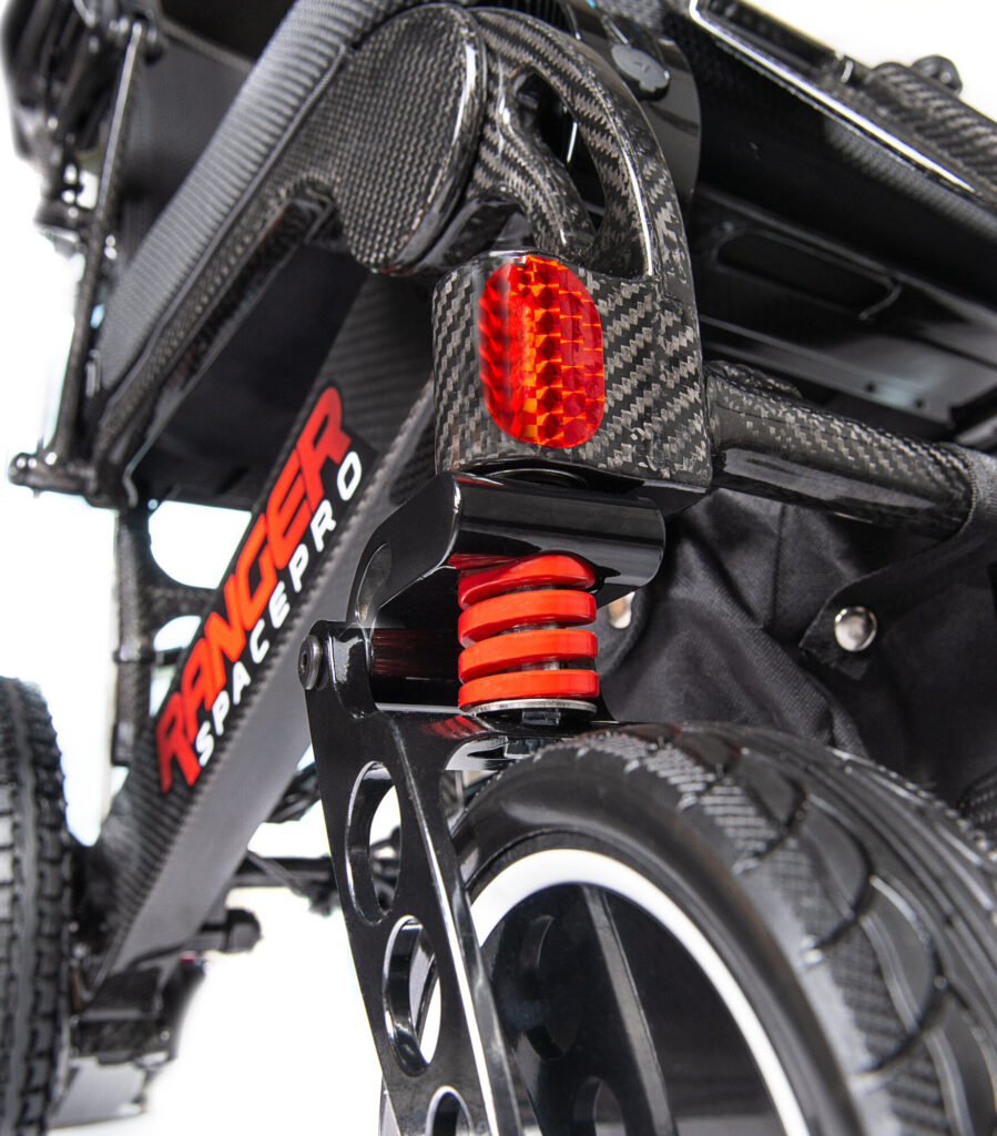Porto Mobility Ranger SpacePro XL folding power wheelchair, front caster spring and reflector close up